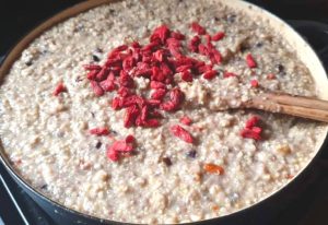 Large pot of porridge with goji berries on top.