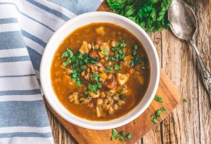 Spicy lentil soup in a bowl on a chopping board.