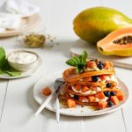 Plate of papaya pancakes on a table.