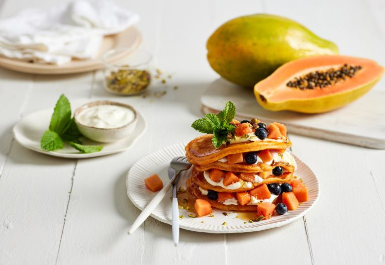 Plate of papaya pancakes on a table.