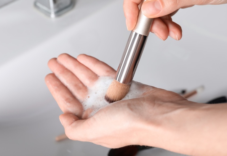 Person washing a makeup brush.