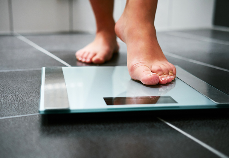 Person stepping onto scales.