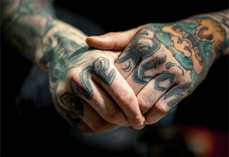 Hands covered in tattoos.