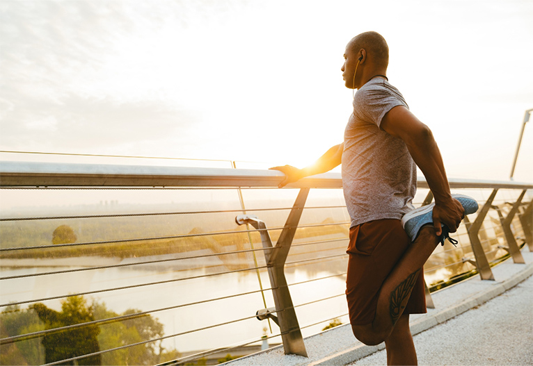 Man stretching on a bridge.