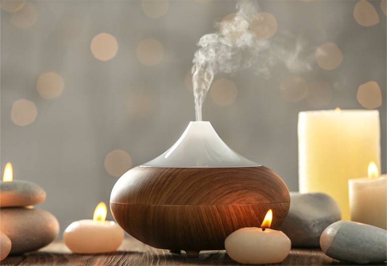 A humidifier surrounded by candles.