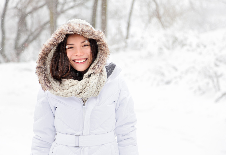 Woman in a white jacket at the snow.