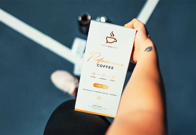 Person holding a box of Beforeyouspeak Performance Coffee.