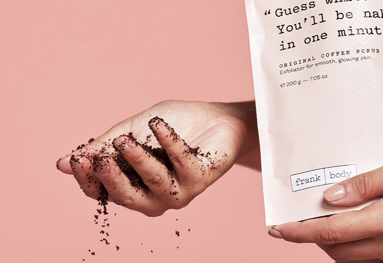 Person holding Frank Body Coffee Scrub.