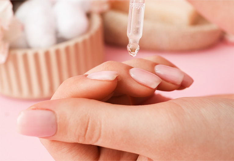 Person applying cuticle oil.