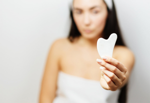 Woman holding a gua sha.
