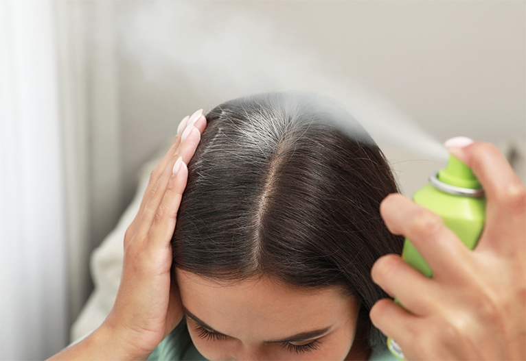 Person using dry shampoo.