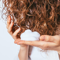 Woman applying products to hair.