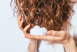 Woman applying products to hair.