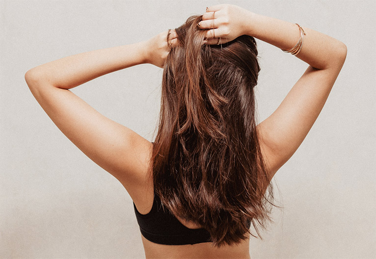 Woman touching her healthy hair.