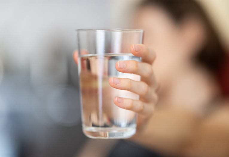 Person holding a glass of water.