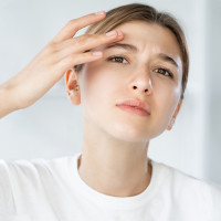 Woman in mirror with skin problems.