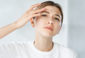 Woman in mirror with skin problems.
