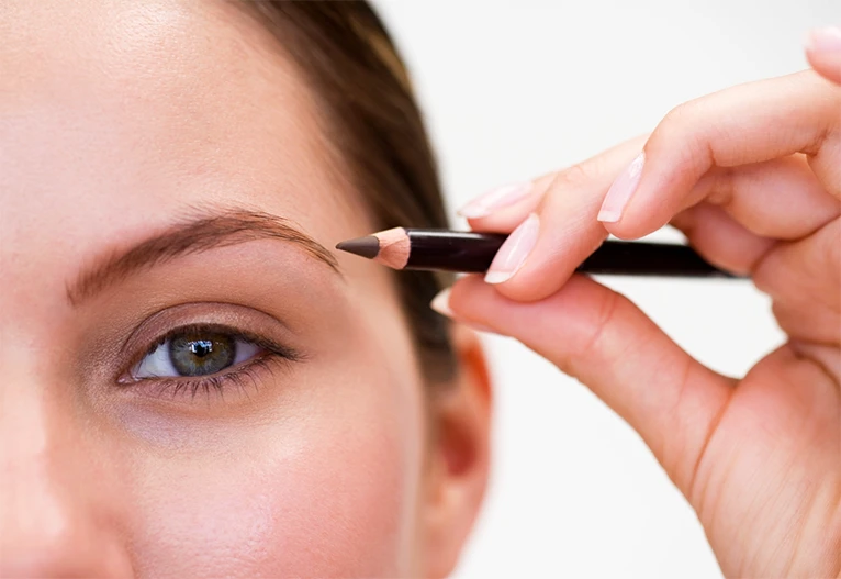Woman using a brow pencil.