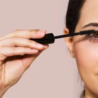 Woman applying mascara.