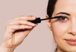 Woman applying mascara.
