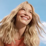 Smiling woman with blonde hair coloured with Clairol Nice'n Easy.