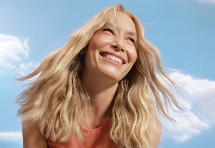Smiling woman with blonde hair coloured with Clairol Nice'n Easy.