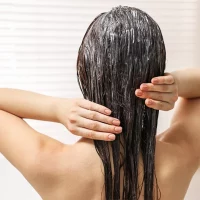 Woman applying a hair treatment.