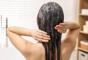 Woman applying a hair treatment.